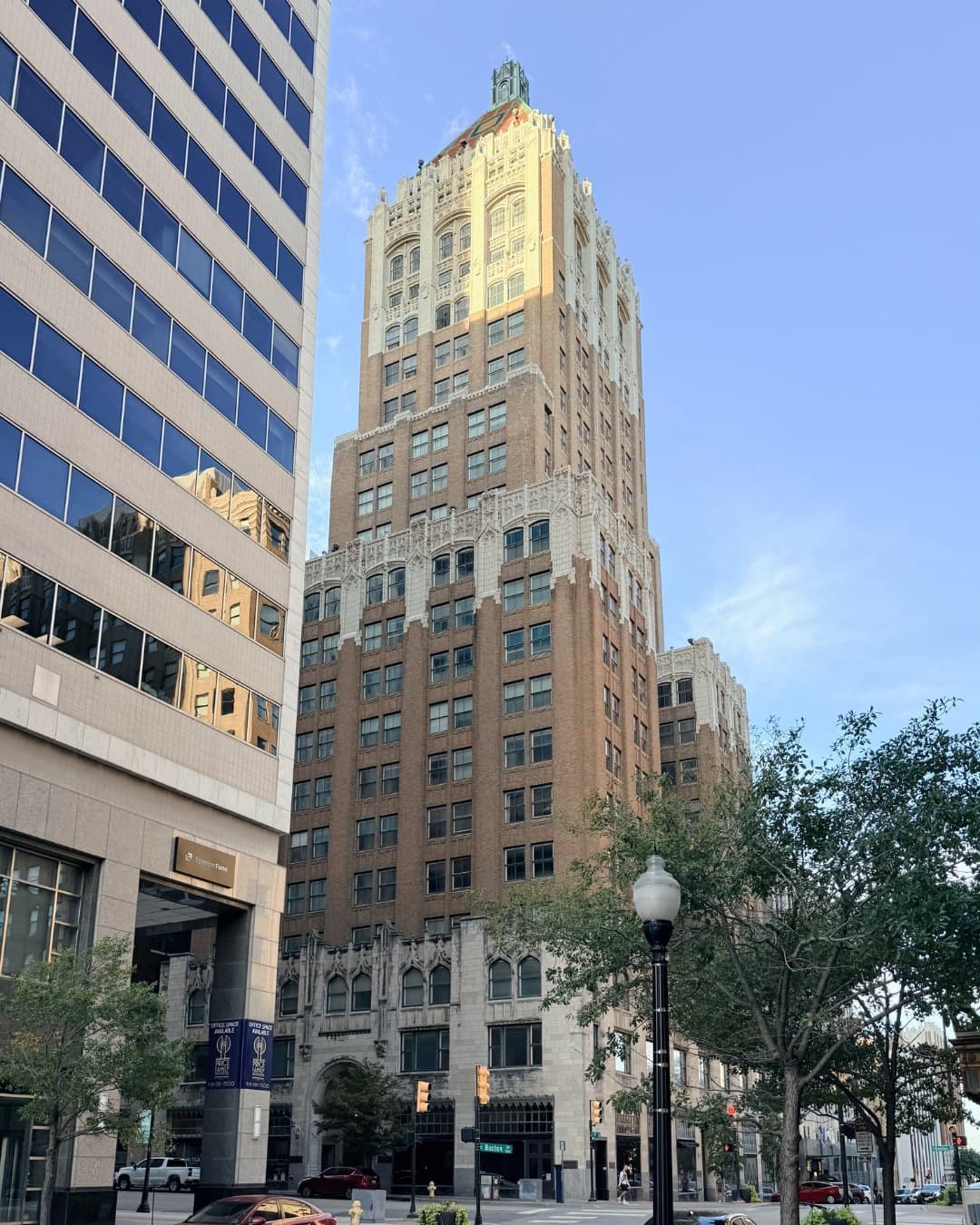 The Philtower from the corner of Fifth Street and Boston Avenue, its Gothic base and lit tiled roof rising past a glass office tower.